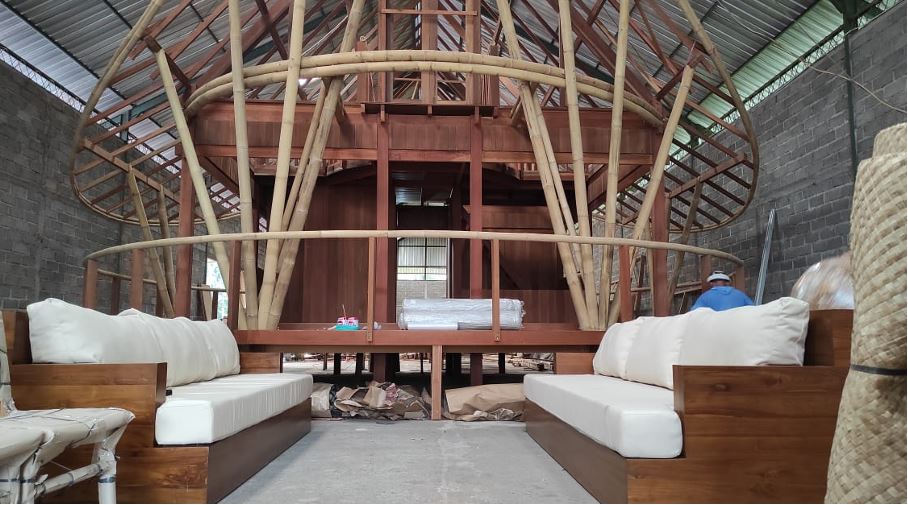 Bamboo and teak wood dome-frame structure under construction inside The Magic Wood's Bali workshop